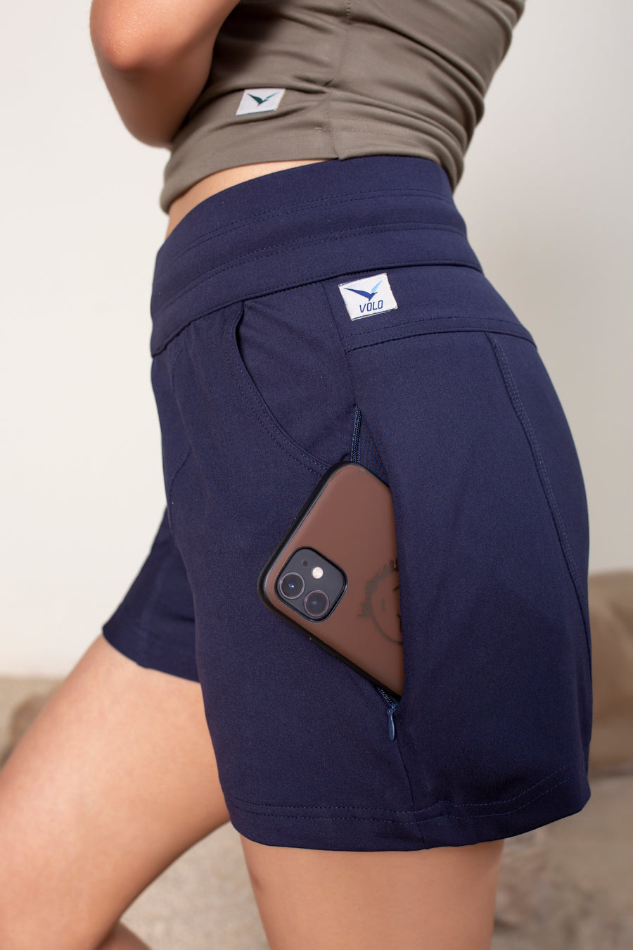 Women's Terra Shorts Navy | VOLO Apparel | A blend of technology, function, and style. The Terra shorts are designed and ready for every active opportunity that comes your way. Your first women's shorts with deep pockets, a snap button smart phone pocket, a zippered key pocket, and a hidden zippered back pocket.  High waisted, great for climbing, yoga, training, running and chilling.