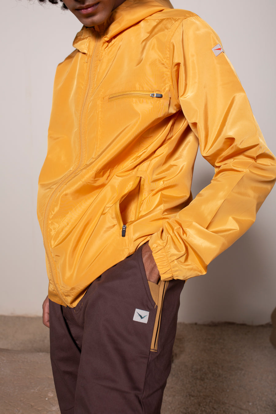 Men's Windansea Jacket in Golden | VOLO Apparel | The ultimate all year jacket, an ultralight hooded windbreaker, crafted with the revolutionary memory fabric and five pockets. This jacket is full of features, water repellant, three zipper pockets, UPF 50 protection from the sun and tailored fit to look super stylish while being ready for any adventure.