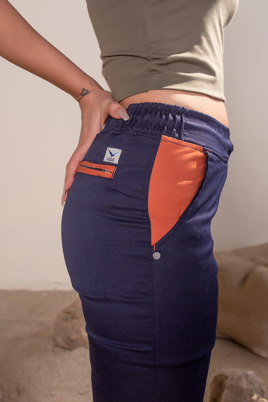 Women's Terra Joggers Navy Orange | VOLO Apparel | Designed for you to rock climb, hike, yoga, run or just chill. The most versatile athletic joggers that are fitted for your every daily life and all your athletic endeavors. The Earth Joggers comes with five pockets, features a 3 point gusset, 2 zipper pockets, snap buttons, and a breathable stretchy spandex cotton twill. With an internal drawstring and a tailored fit, these are gonna be your go to adventure joggers.