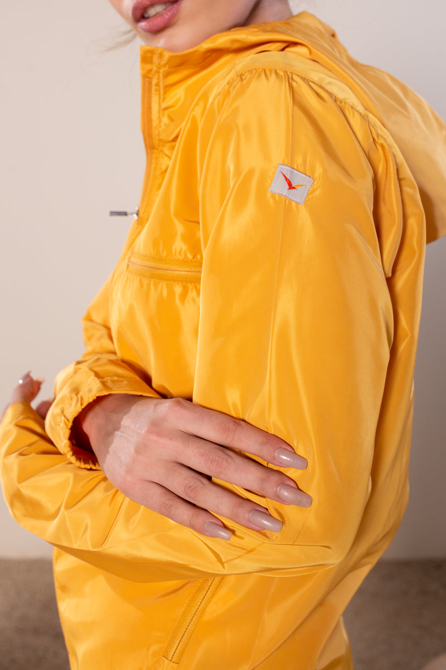 Women's Windansea Jacket in Golden | VOLO Apparel | The ultimate all year jacket, an ultralight hooded windbreaker, crafted with the revolutionary memory fabric and five pockets. This jacket is full of features, water repellant, three zipper pockets, UPF 50 protection from the sun and tailored fit to look super stylish while being ready for any adventure.