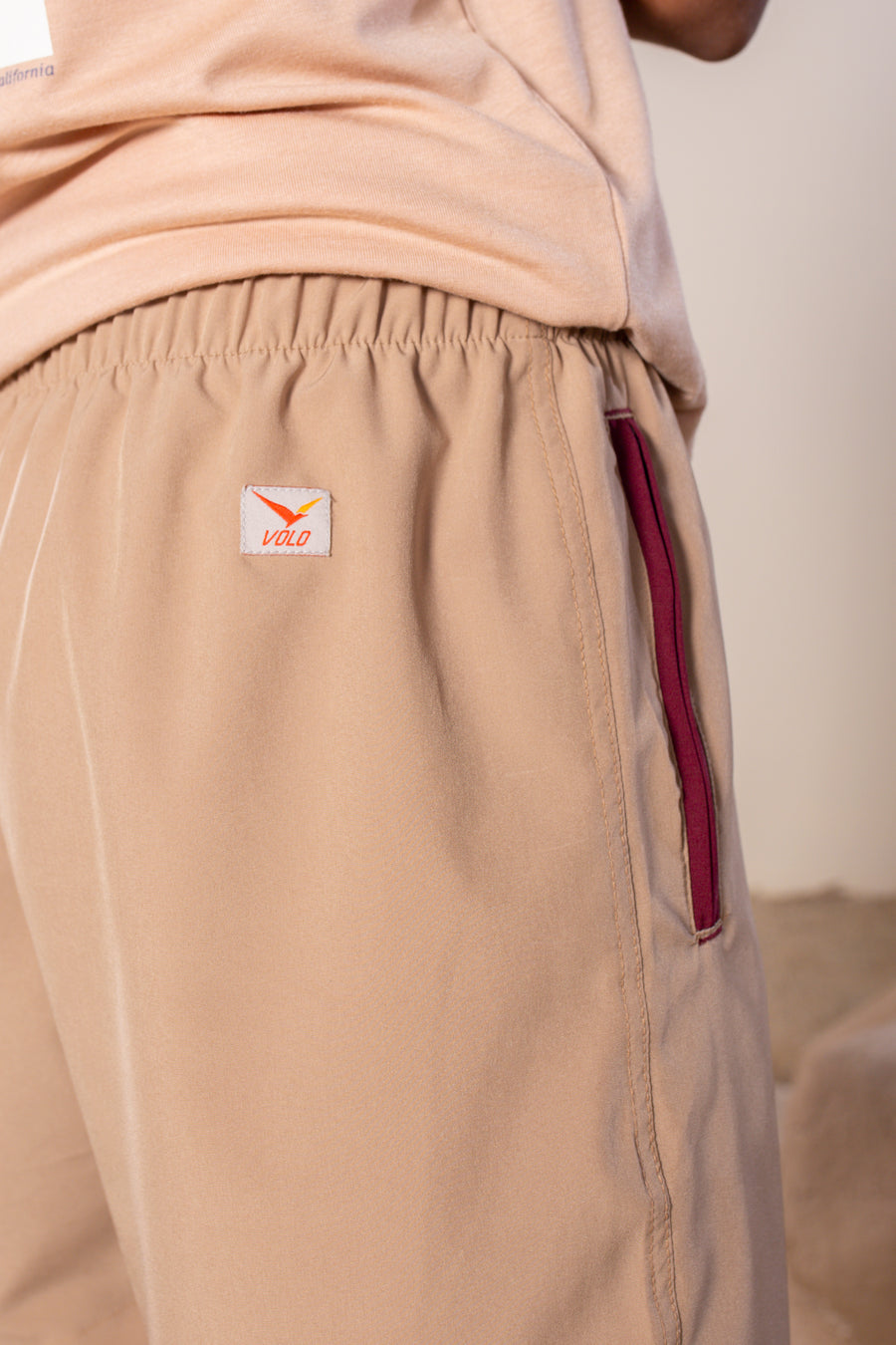 Men's Flight Shorts in Tan | VOLO Apparel | Designed so you can feel fly and completely secure, the Flight Shorts 2.0 are made with an ultralight micro stretch fabric that is quick drying and comes with a three zipper pocket design. The smart pocket tech makes it so your stuff won’t bounce when you do. Reinforced stitching so it can handle everything you will throw at it. The one short for your every adventure.